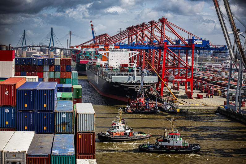 Intermodal Transport - a tug boat in the water next to a large cargo ship