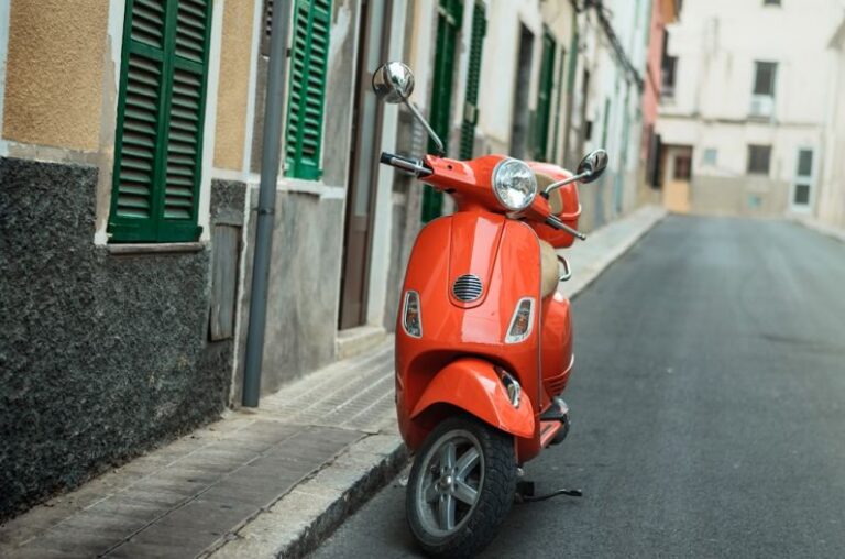 Telematics Transport - red motor scooter on street during day time