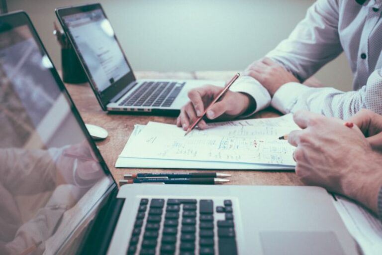 Risk Management - person holding pencil near laptop computer