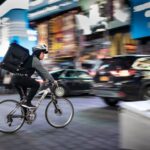 Fast Delivery - man riding bicycle near vehicles