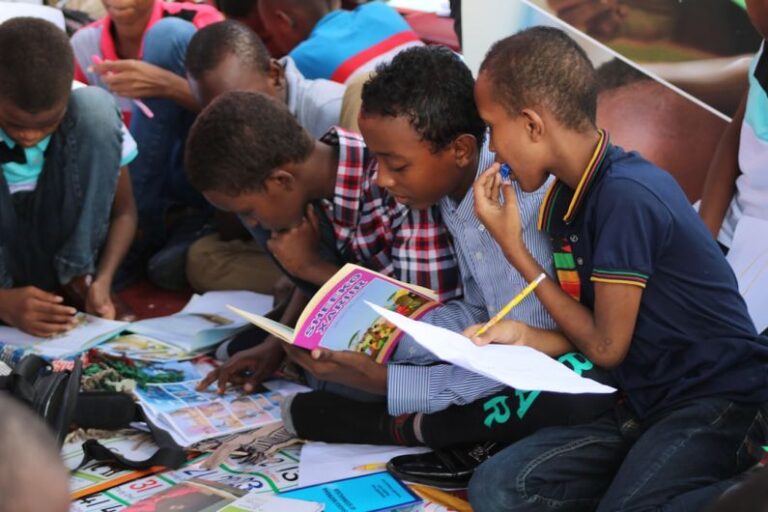 Learning Logistics - boy in blue and white plaid shirt reading book