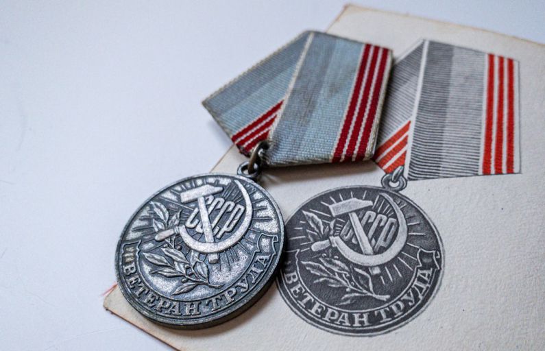 Certification Badge - silver round coin on white textile