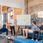 Jobs Future - three men sitting while using laptops and watching man beside whiteboard