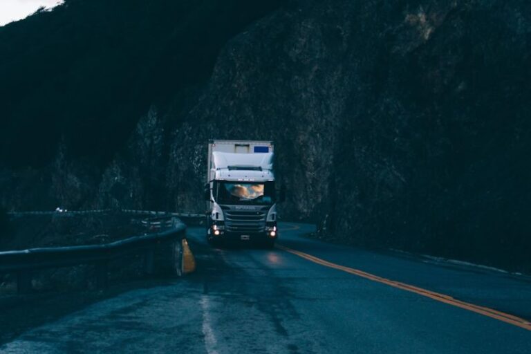 Electric Truck - trailer truck passing on road near rail guard