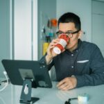 Visibility Monitor - man in black and white checkered dress shirt drinking from brown and white ceramic mug