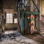 Stopwatch Factory - black metal gate near concrete wall