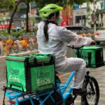 Last-mile Delivery - a person riding a bike with a cooler strapped to the back