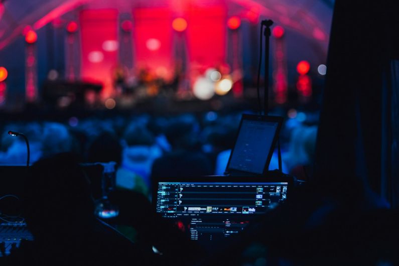 5G Technology - a stage with a laptop and microphone in front of a crowd