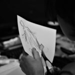 Cost Cutting - grayscale photo of woman holding pen writing on white paper