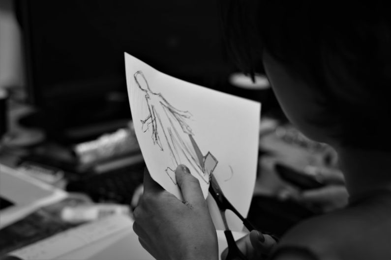 Cost Cutting - grayscale photo of woman holding pen writing on white paper